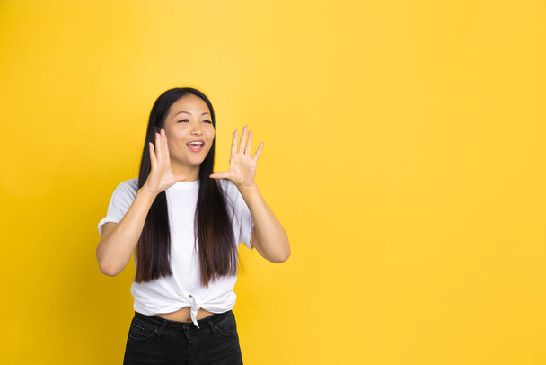 Portrait of young asian woman isolated on yellow studio background - Φωτογραφία, εικόνα