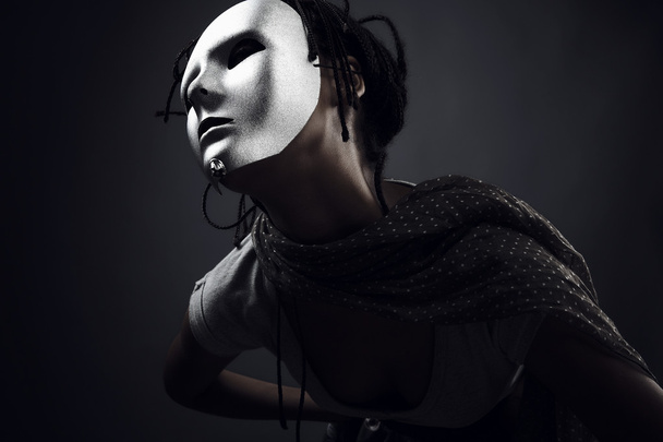 Gloomy woman in silver mask posing on a black background. - Фото, изображение