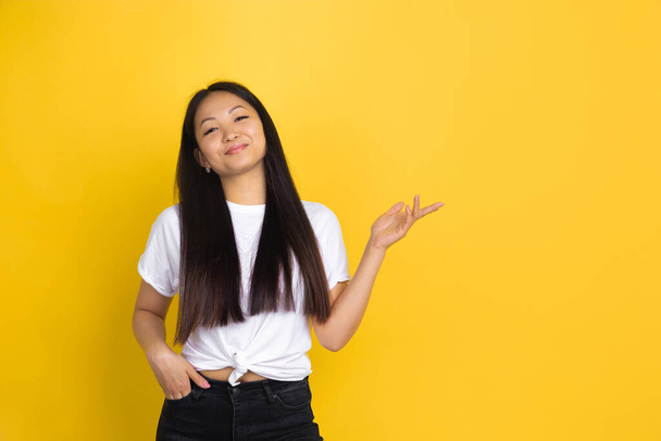 Portrait of young asian woman isolated on yellow studio background - Photo, image