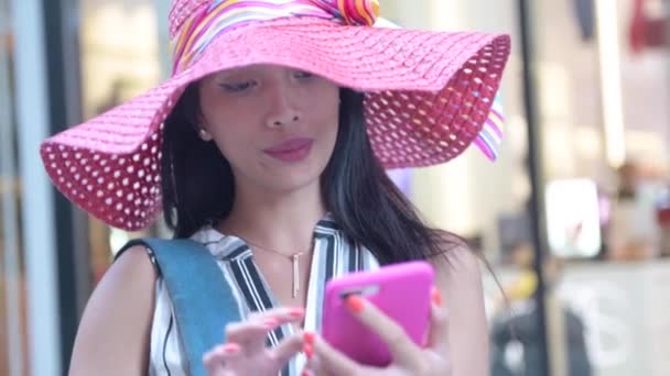 Ázsiai lány rózsaszín kalap írás üzenet mobiltelefon - Felvétel, videó