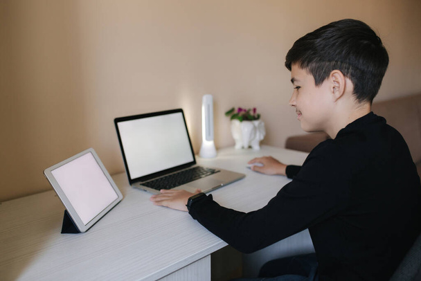 Nastolatek na palcach w domu. Młody chłopiec gra w gry online w domu. Ucz się w kwarantannie. Szczęśliwy uczeń podczas krantyny - Zdjęcie, obraz
