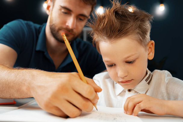 Father helping his little son with school homework - Fotó, kép