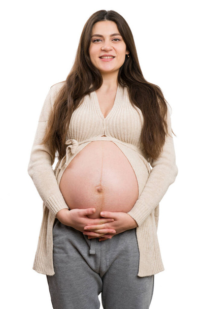 gelukkig zwanger vrouw houden haar buik met handen gekruist geïsoleerd op witte achtergrond als zorg concept - Foto, afbeelding