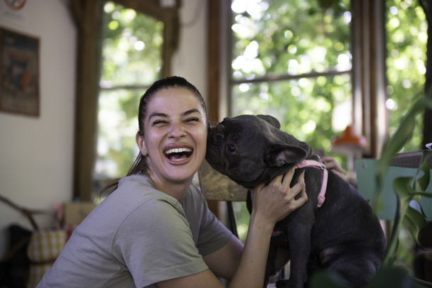 Lány szerető és csók kutyája belsejében egy kis állatbarát kávézó - Fotó, kép