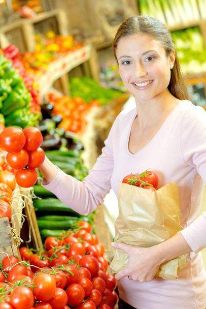 she is shopping for some tomatoes - Valokuva, kuva