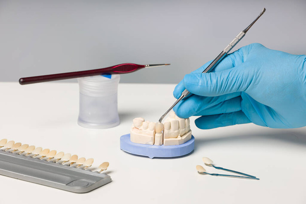 Close-up van het werken op kunstgebitdelen in tandtechnisch laboratorium  - Foto, afbeelding