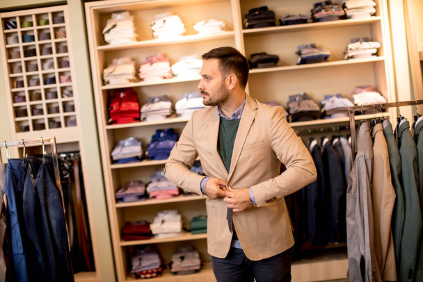 Hezký mladý muž kupovat oblek v obchodě - Fotografie, Obrázek