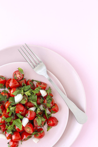 Homemade cherry tomato salad with fresh onions, mint, olive oil and salt. Vegan food. Healthy food concept - Photo, Image