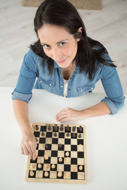 a woman is playing chess - Фото, зображення