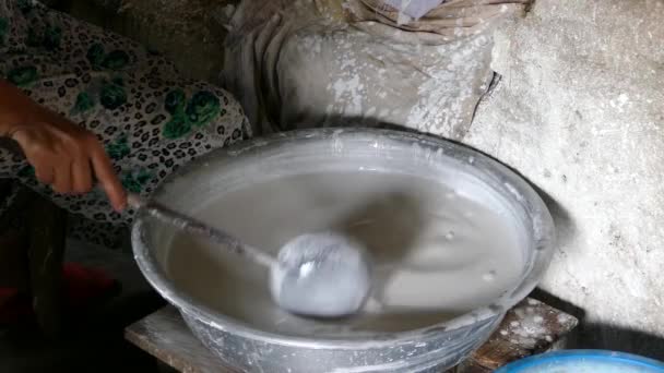 Miska z nasączonym surowego ryżu i wody do produkcji papieru ryżowego w Hoi An Wietnam - Materiał filmowy, wideo