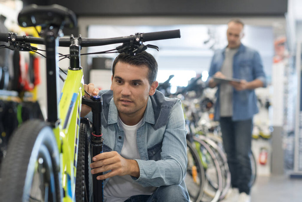happy smiling man choosing new sport bike in store - Foto, imagen