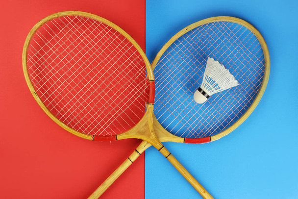 badminton rackets and shuttlecock on a red and blue colored background - Photo, Image