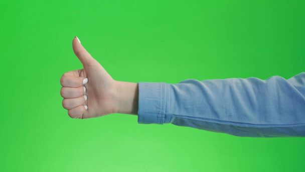 Daumen hoch, Handbewegung auf grünem Bildschirm. Simbol der Zustimmung wie positive Emotionen. - Foto, Bild