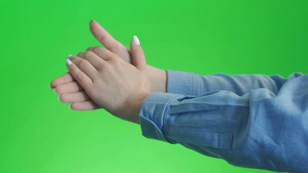 Κορίτσι κάνει χειροκροτεί τα χέρια της σε ένα πράσινο φόντο οθόνη - Φωτογραφία, εικόνα