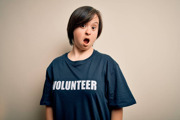 Jovem para baixo síndrome voluntária mulher vestindo assistência social caridade camiseta Em face de choque, olhando cético e sarcástico, surpreso com a boca aberta
 - Foto, Imagem