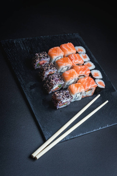 Sushi on a black background. Perfect for creating a sushi restaurant menu. Japanese cuisine, Eastern culture. - Photo, image