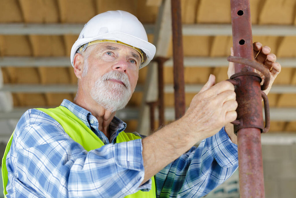 senior man looking through construction pipes - Φωτογραφία, εικόνα