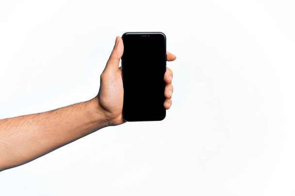 Main de caucasien jeune homme tenant smartphone montrant écran sur fond blanc isolé - Photo, image
