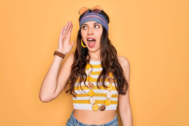Young beautiful hippie woman with blue eyes wearing accesories and sunnglasses shouting and screaming loud to side with hand on mouth. Communication concept. - Fotoğraf, Görsel