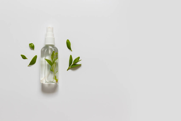 Beautiful horizontal background with natural liquid lotion with green leaves on white background. Flat lay, top view - Valokuva, kuva