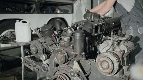 Mecánico masculino que trabaja en el mantenimiento y la reparación del motor diesel del autobús del coche
.  - Metraje, vídeo