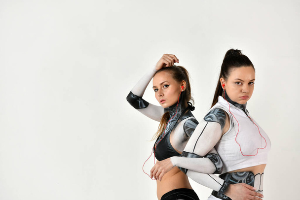 two beautiful girls in robotic costumes as two sisters look after each other - Photo, Image