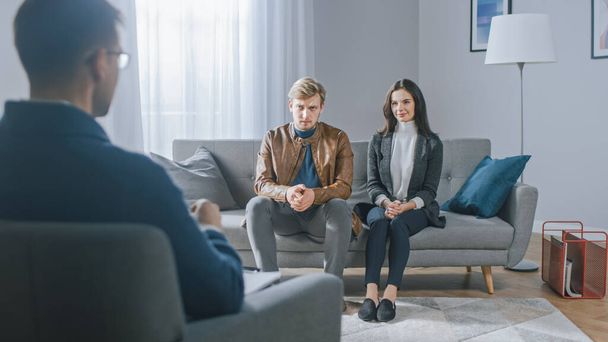 Young Couple on a Counseling Session with Psychotherapist. Back View of Therapist: Young People Sitting on the Analyst Couch, Discussing Psychological Trauma, Relationship Problems, and Suffering - Foto, Bild