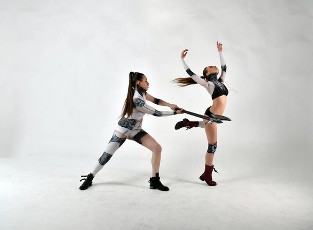 kaksi kaunista tyttöä robottipuvuissa kun lapset taistelevat aseita ja improvisoituja keinoja vastaan - Valokuva, kuva
