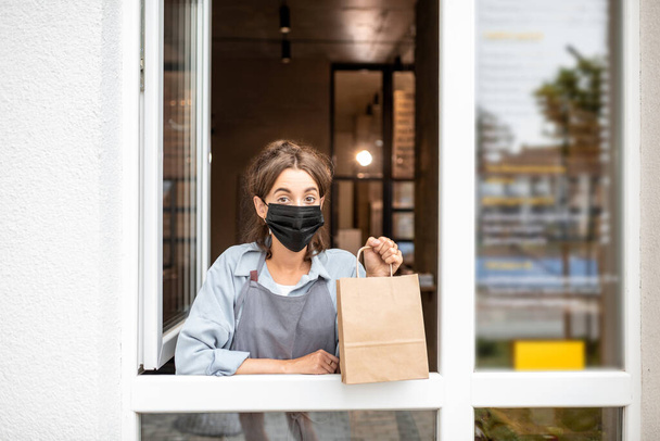Woman with food to take away in the shop window - Photo, Image