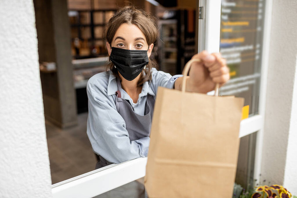 Žena s jídlem vzít pryč v okně obchodu - Fotografie, Obrázek