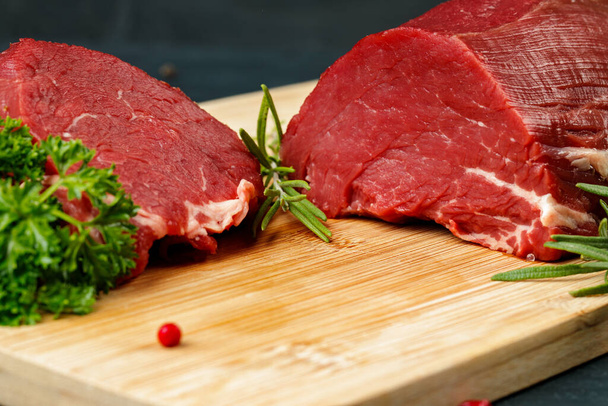 Slice of raw beef fillet on wooden board - Фото, зображення