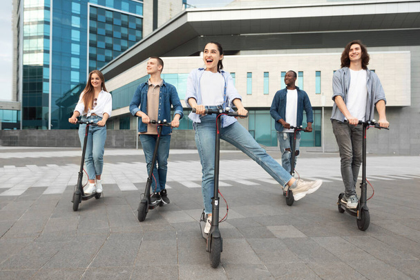 Vrienden hebben aangename rit op gemotoriseerde kick scooters - Foto, afbeelding