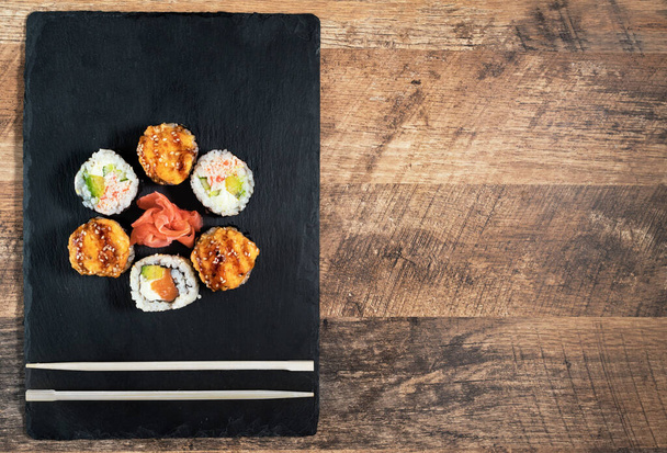 Set de rollos de sushi en la placa negra. Comida japonesa
. - Foto, Imagen