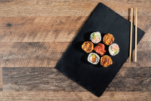 Rotolo di sushi sulla piastra nera. Cibo giapponese. - Foto, immagini