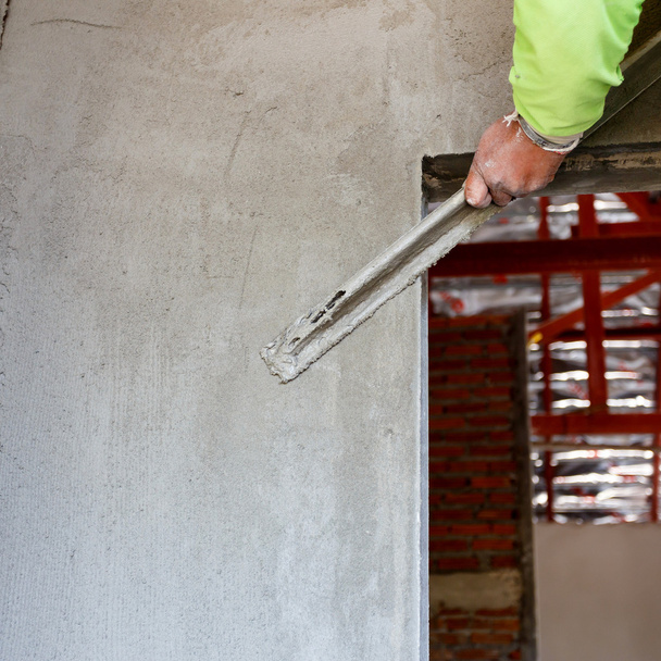 plasterer concrete worker at wall of house construction - Valokuva, kuva