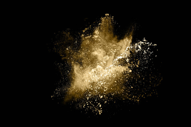 Goldene Pulverexplosion auf schwarzem Hintergrund. Gefrierbewegung. - Foto, Bild