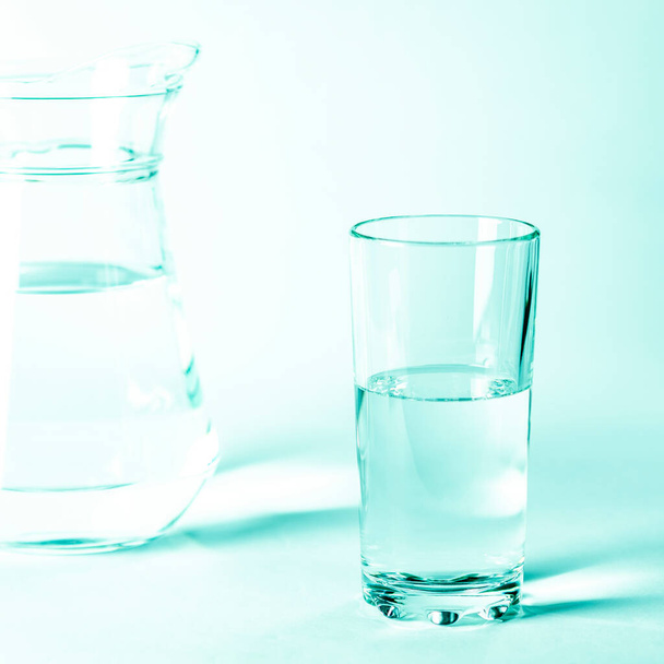 Glass with clean clear water and shadows on a white background - Photo, Image