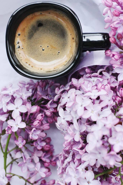 Beautiful bouquet of lilac and a Cup of Americano coffee  - Foto, afbeelding