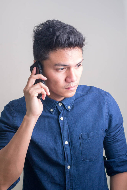 Studio shot of young handsome Filipino businessman against white background - Foto, Imagen