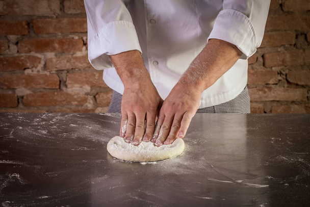 Fresh pizza dough being prepared. The process of making pizza - Photo, Image