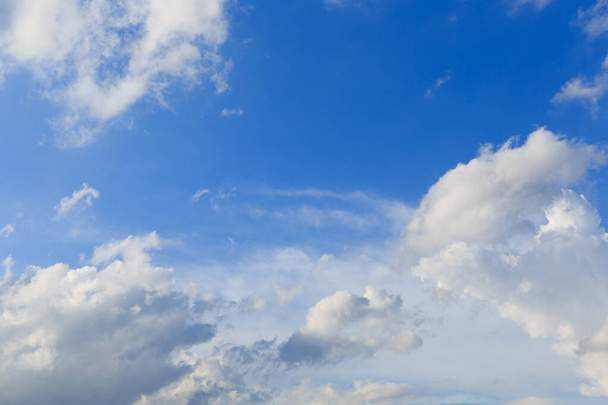Witte wolken tegen de blauwe lucht achtergrond in zonnige bewolkte zomerdag. - Foto, afbeelding