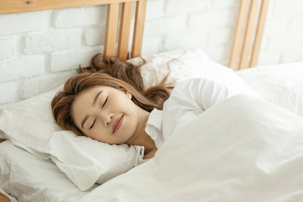 美しい魅力的なアジアの女性はとてもリラックスして快適な朝の感じでベッドルームで寝ると甘い夢,ヘルスケアコンセプト - 写真・画像