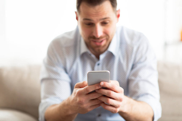 Handsome adult man using smart phone at home - Photo, Image