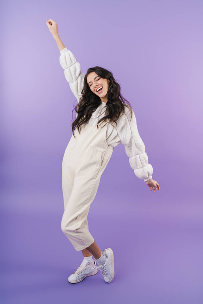 Image of happy positive cute young brunette woman posing isolated over purple wall background. - 写真・画像