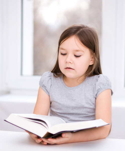 Little girl is reading a book - Fotó, kép