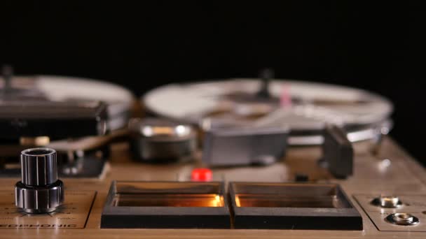 Studyjne ujęcie starego, stożkowego magnetofonu Vintage Reel to Reel, grającego muzykę.Zbliżenie mierników VU.Kręcone w rozdzielczości 4K Ultra HD na czarnym tle. - Materiał filmowy, wideo