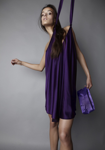 Сексуальная брюнетка позирует в шелковом фиолетовом платье
. - Фото, изображение