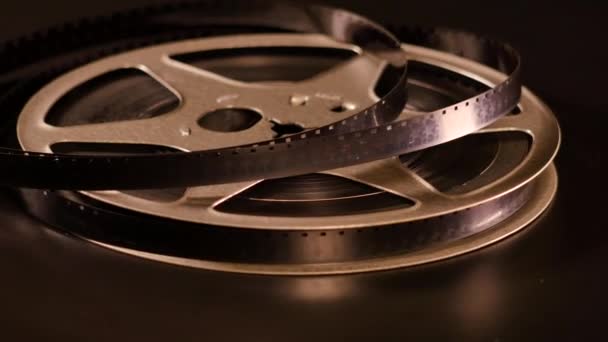 Περιστροφή ταινίας σε κύλινδρο πριν από το μαύρο φόντο - Πλάνα, βίντεο