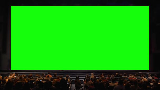 Personas en el auditorio con pantalla de croma
 - Foto, imagen