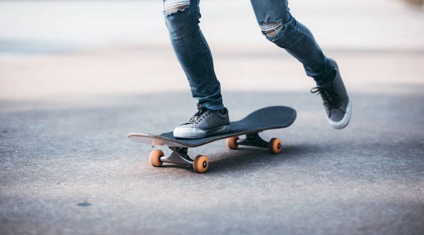 Skateboarder legs skateboarding at outdoors in the parking lot - Zdjęcie, obraz